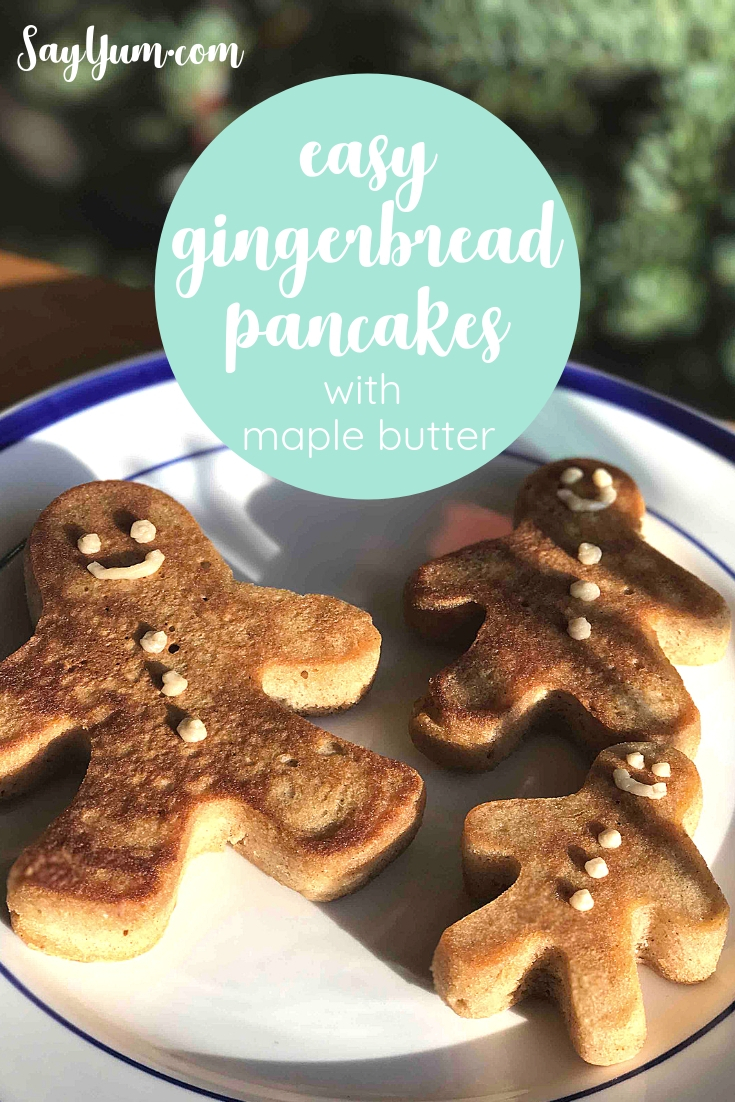 plate of easy gingerbread pancakes in gingerbread men shapes decorated with maple butter frosting with christmas tree in background